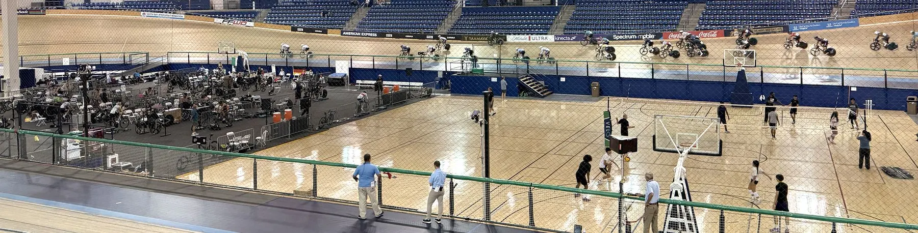 The VELO Sports Center velodrome in Carson, with riders on the boards under rows of national flags.